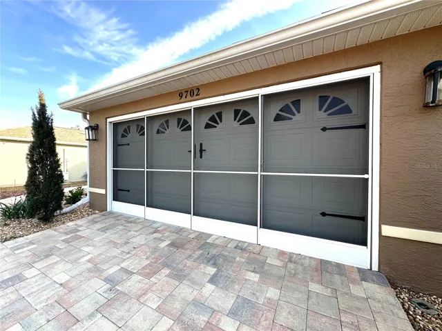 SLIDING SCREEN GARAGE DOORS & PAVERS ON DRIVEWAY