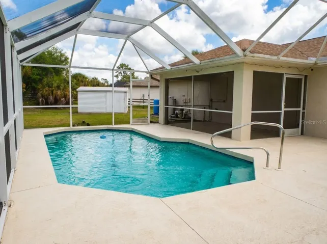 tep out into your private Florida oasis featuring a sparkling inground pool fully enclosed by a expansive screened lanai, offering the perfect setting for year-round entertaining and relaxation.