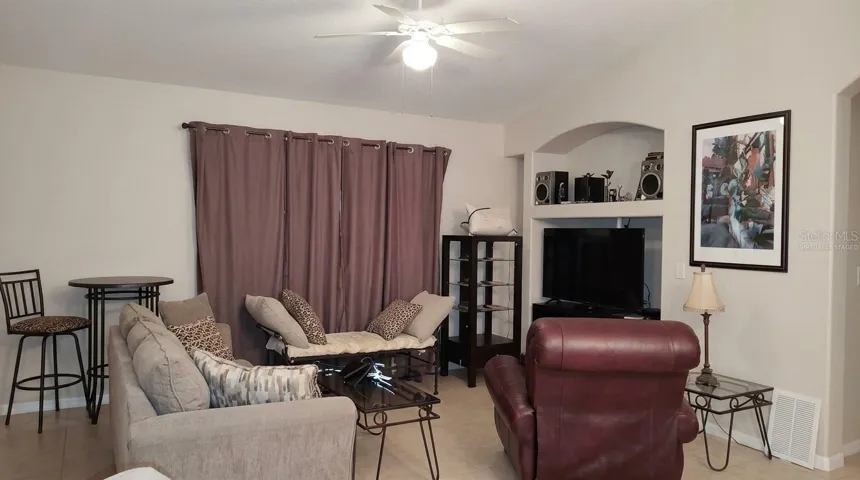 This spacious, virtually staged primary living area is an ideal gathering spot, open up to enjoy the natural light and featuring elegant ceramic tile throughout.