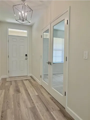 Just inside is a bonus room with glass french doors to the left.