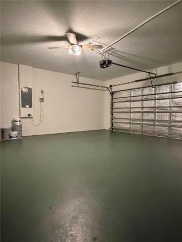 There's a ceiling fan in the garage, and the concrete floor was painted a deep emerald green.  There's also a motion detector that turns the light on for you.  The garage door opener is brand new.