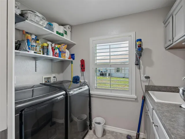Inside Laundry rm w/Sink, Counter, Cabinets, & Plantation shutters