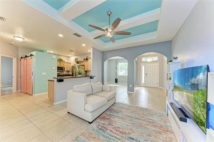 Living room leading to the kitchen, entryway and dining area