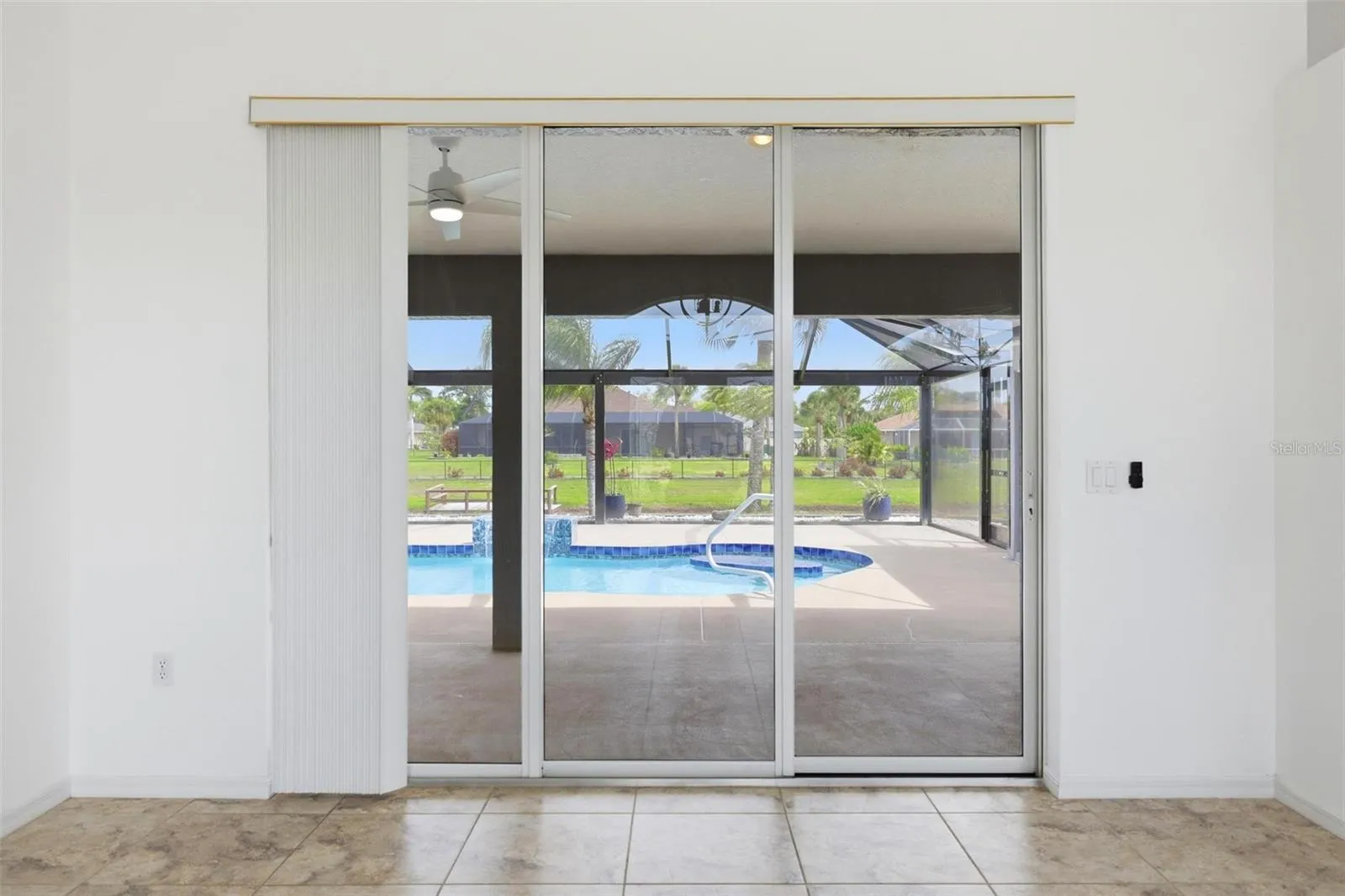 Bright living area with sliding glass doors overlooking the extended screened lanai
