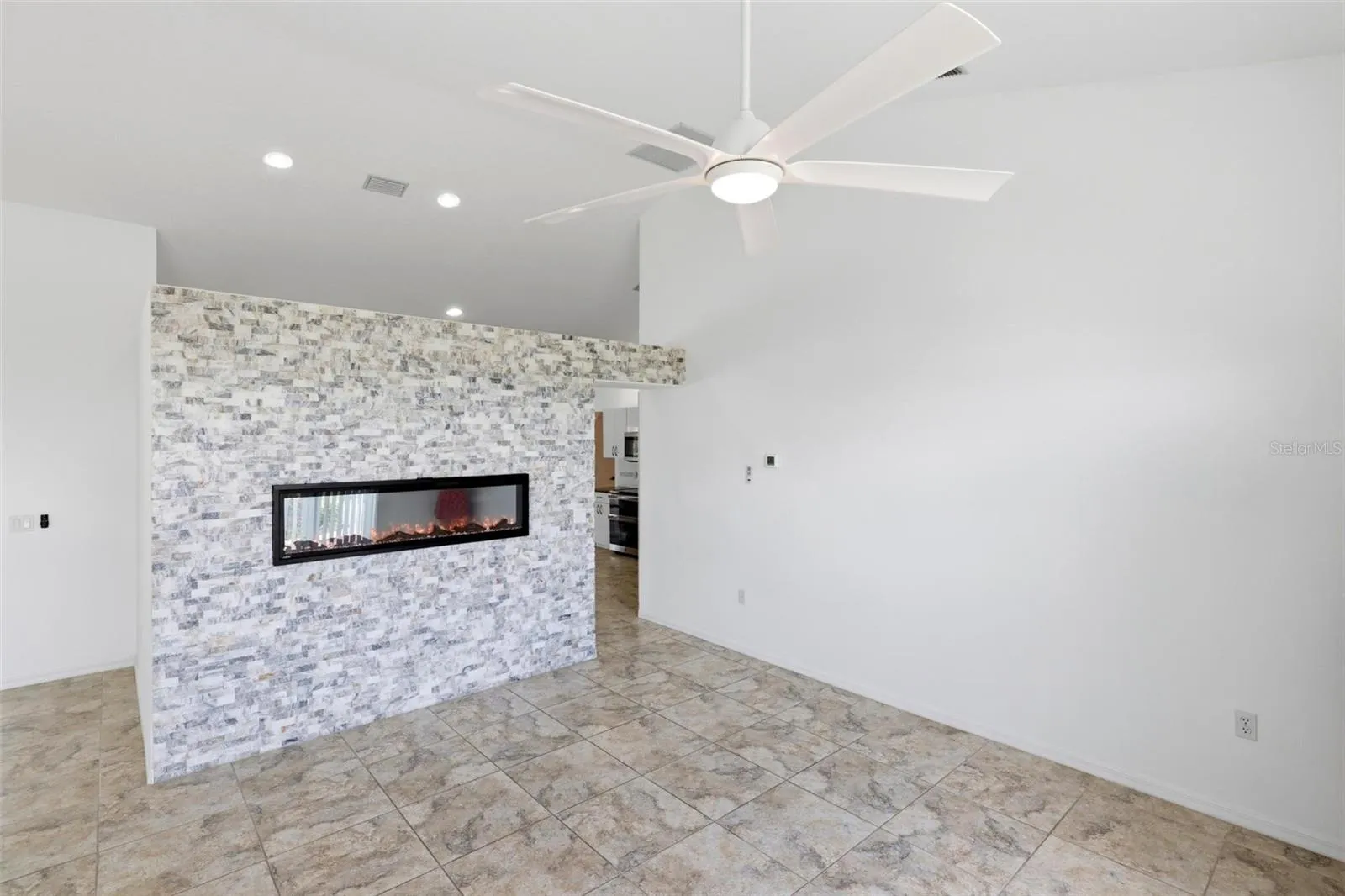 Cozy room with decorative accent wall, ceiling fan, and comfortable neutral finishes