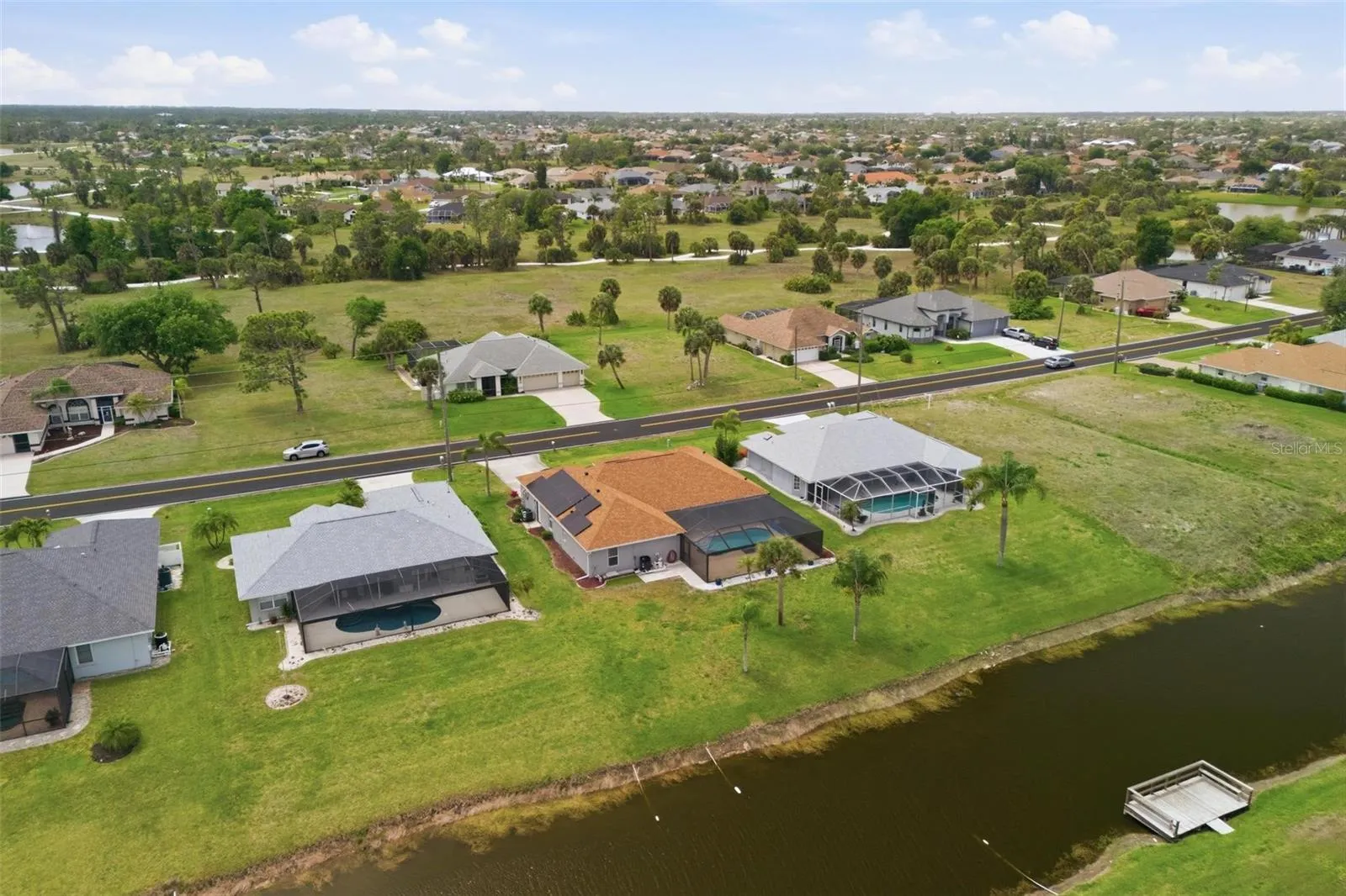 Overhead view of property showing pool enclosure, 2023 roof, and spacious backyard