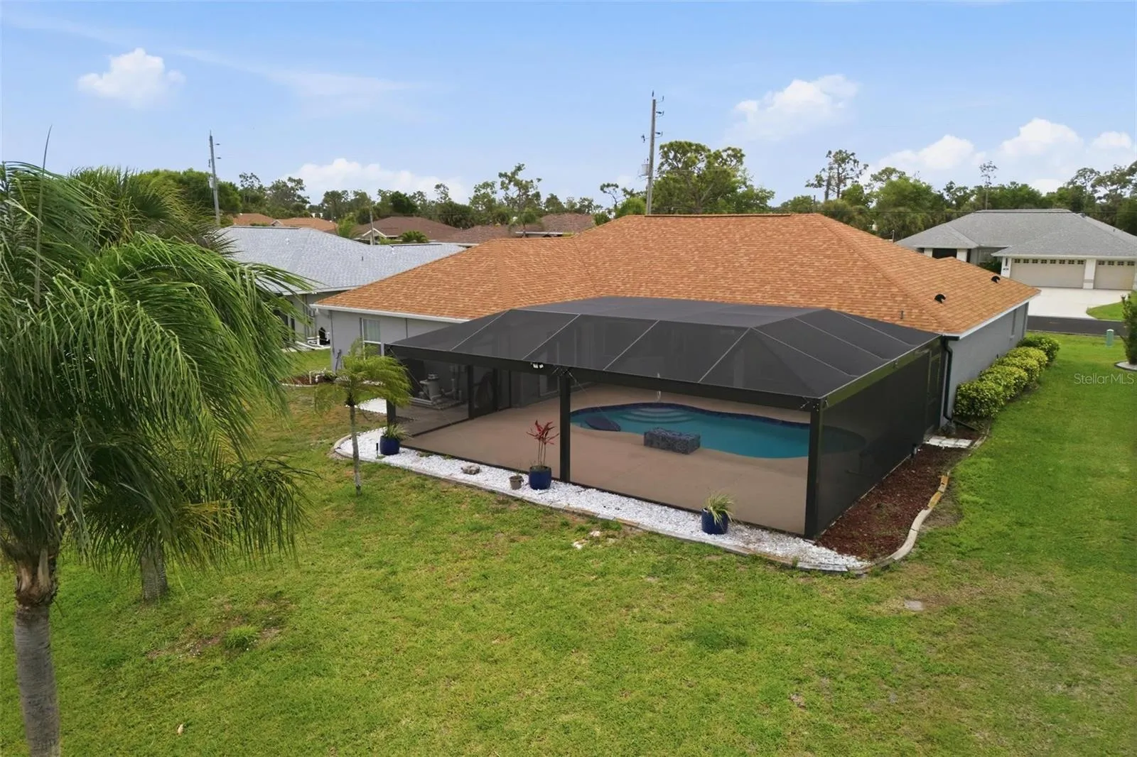 Bird's-eye view showcasing home layout, newly redone pool, and landscaped grounds