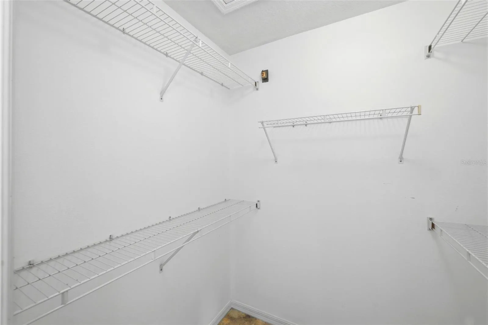 Large walk-in closet with rod and shelf system, ready for your personal touch