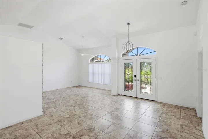 Open room with large windows, tile flooring, and clean move-in ready finishes