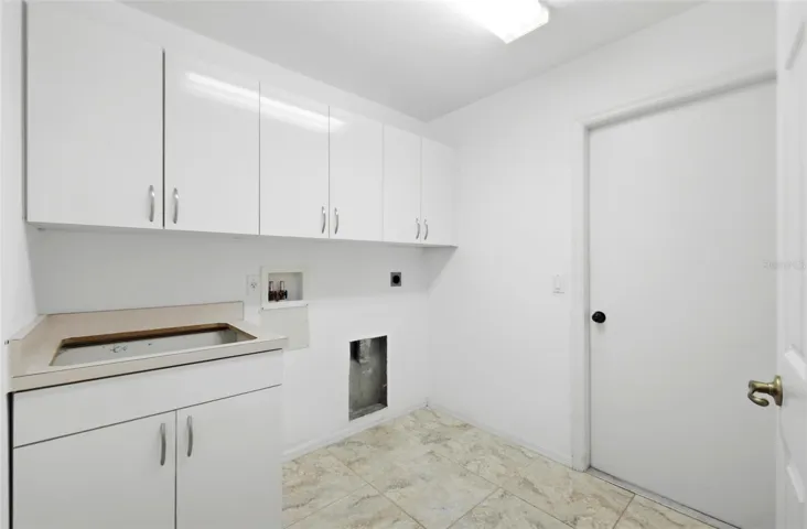 Spacious laundry room with ample storage and move-in ready condition, includes new washer/dryer (2024)