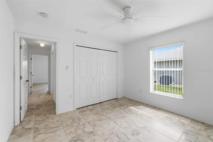 Spacious bedroom with large window, neutral tones, and move-in ready condition