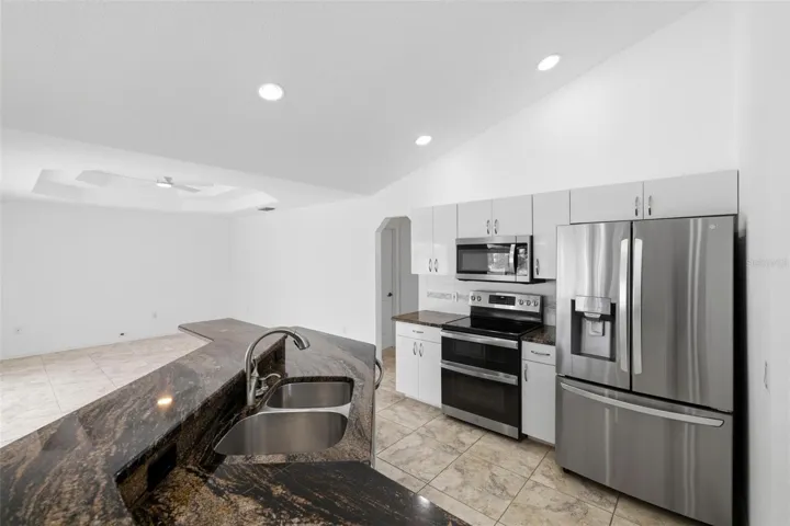 Modern kitchen featuring all-new 2024 appliances, dark countertops, and island seating