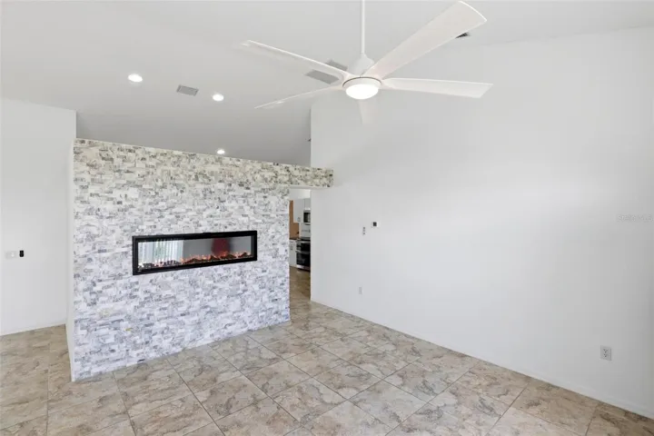 Cozy room with decorative accent wall, ceiling fan, and comfortable neutral finishes