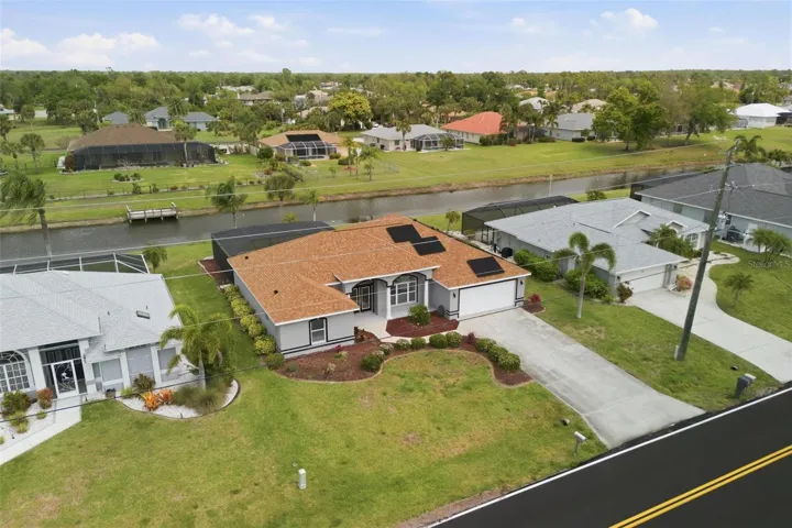 Wide aerial view showcasing no-flood-zone lot, pool, and tranquil surroundings