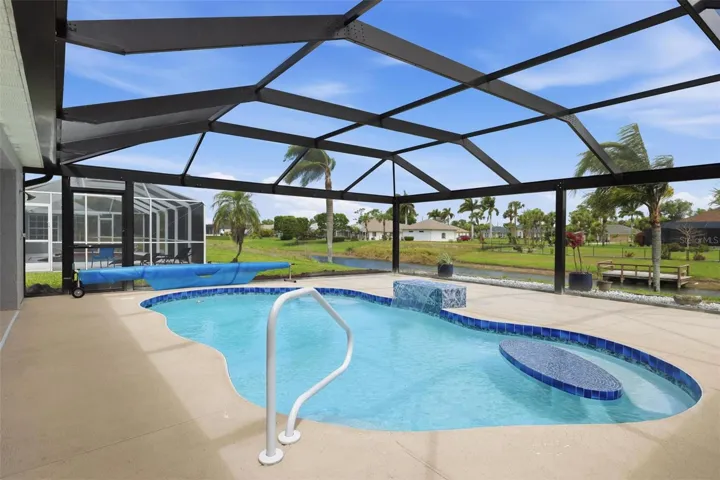 Spacious screened lanai showcasing newly redone pool and open surrounding views
