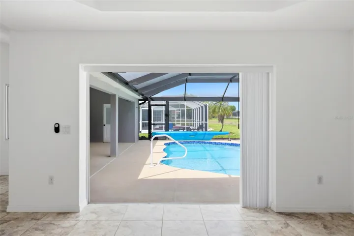 Sun-filled room with large windows offering relaxing views of the pool area
