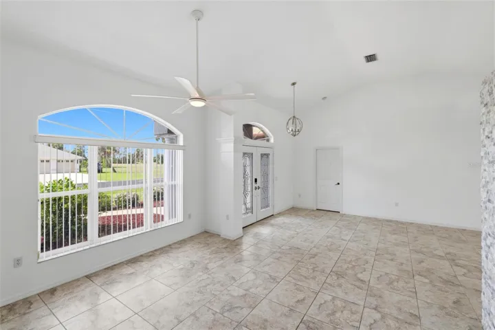 Bright foyer or bonus room with arched window and elegant tiled flooring
