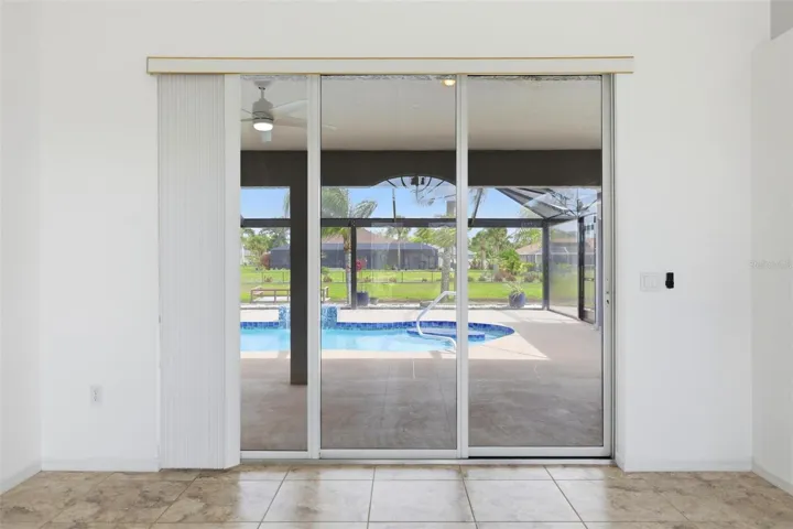 Bright living area with sliding glass doors overlooking the extended screened lanai