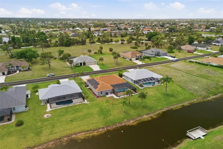Overhead view of property showing pool enclosure, 2023 roof, and spacious backyard