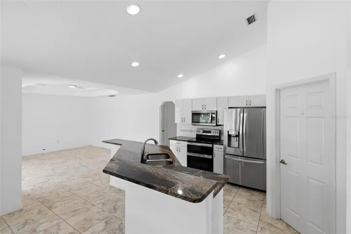 Well-appointed kitchen with new 2024 microwave, dark counters, and recessed lighting