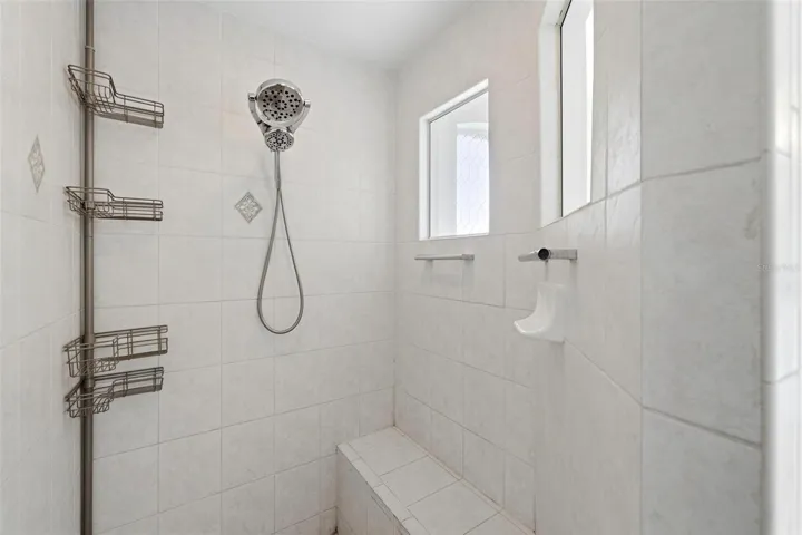 Walk-in shower with glass enclosure, tile surround, and updated modern fixtures