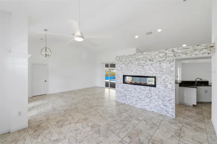 Open living space with tile floors, recessed lighting, and clean neutral tones