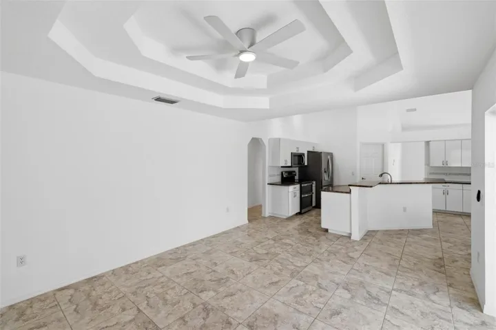 Open-concept kitchen and living area with coffered ceiling and modern finishes