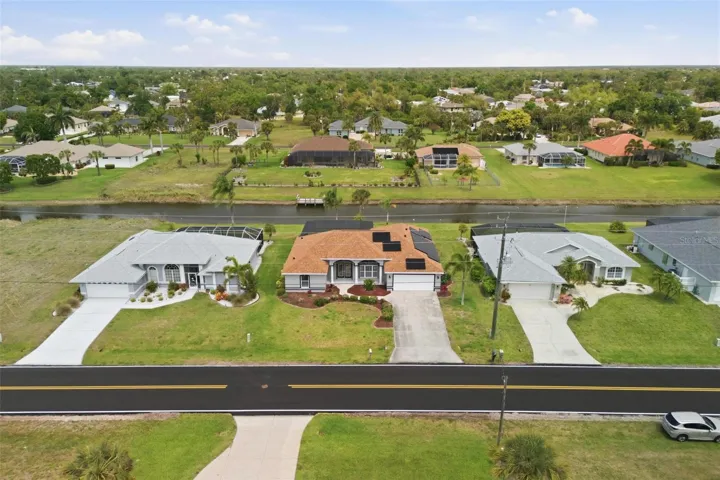 Aerial shot highlighting home's footprint, pool, and peaceful canal-side setting