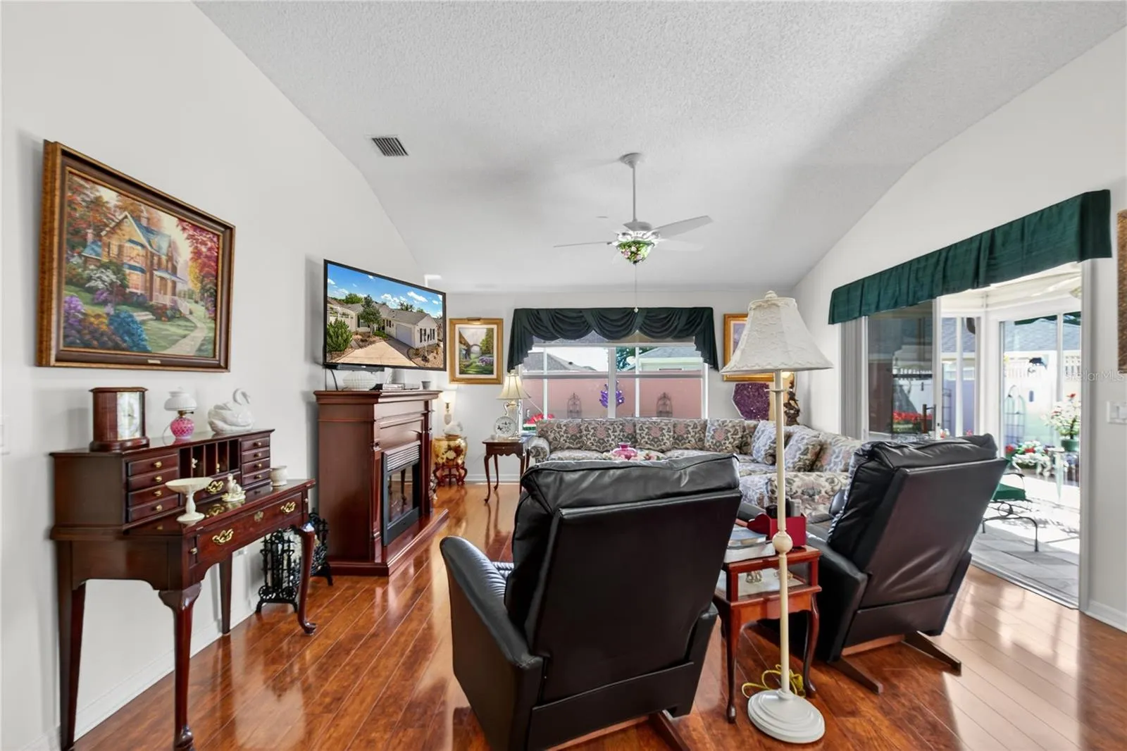 LIVING ROOM BOASTS VAULTED CEILING, ELECTRIC FIREPLACE, VIEWS OF THE TROPICAL GARDEN IN THE COURTYARD