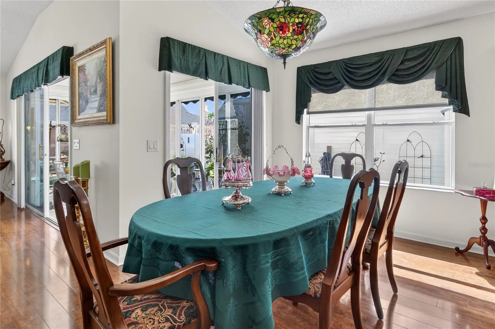 The Dining Room and Living Room both feature elegant glass sliders, providing seamless access to the inviting and comfortable enclosed lanai, enhancing the indoor-outdoor living experience.