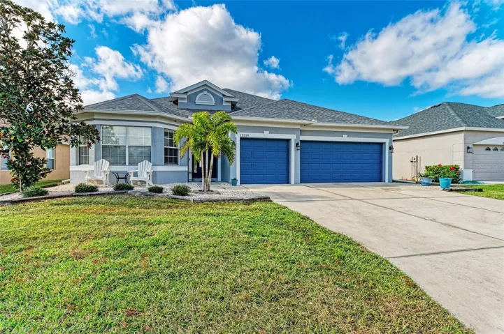 Front exterior with 3 car garage and large driveway.