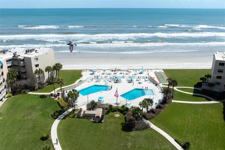 Two oceanfront pools on tiled deck with lots of tables & chairs overlooking seawall & private walk to beach!