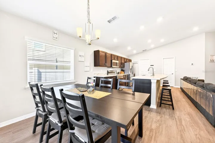 The Dining area is filled with NATURAL LIGHT, enhanced by a large window and sliding glass doors.