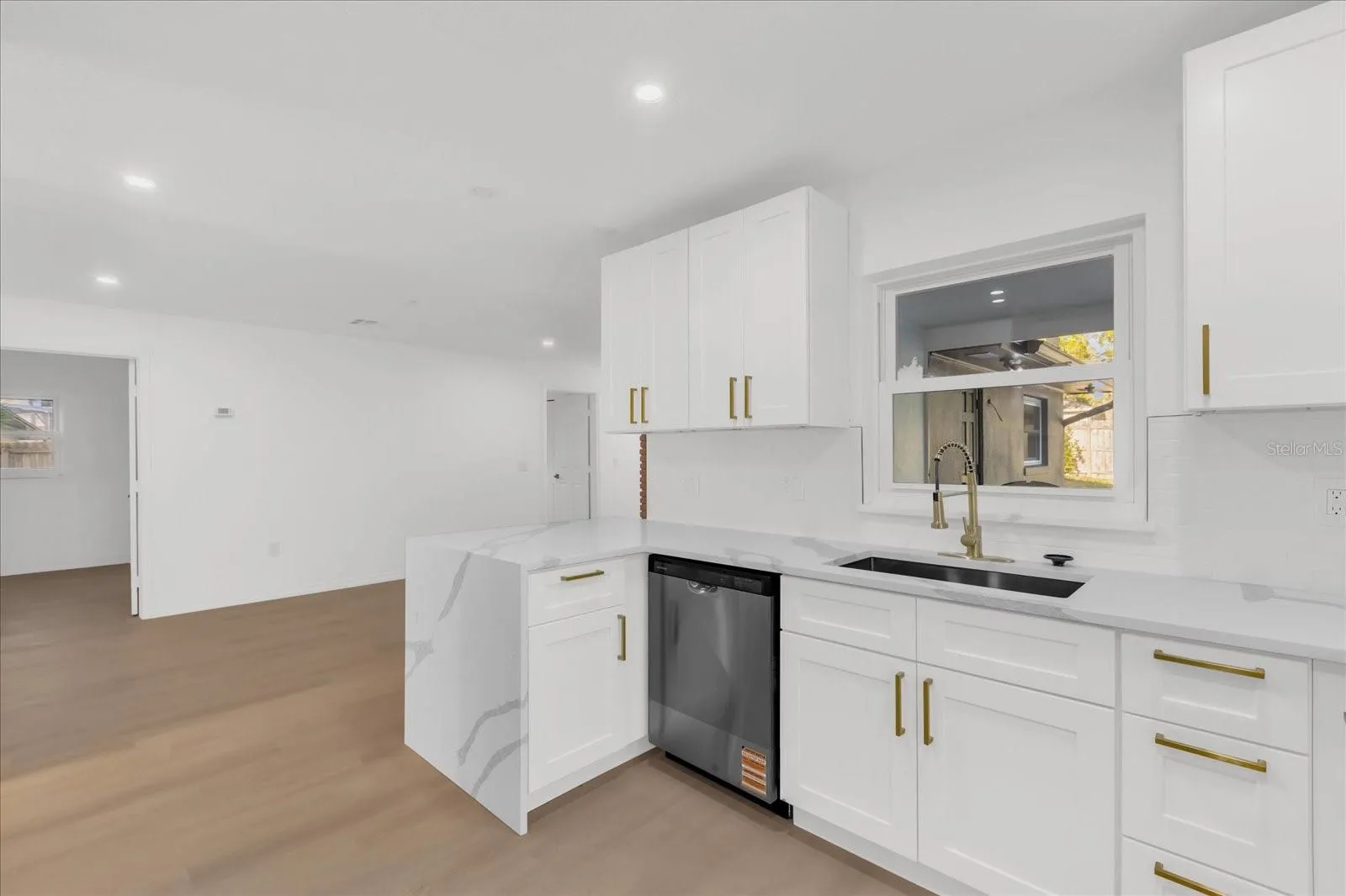 The Kitchen  easily flows to the family room for access to the screened in patio. The window also opens in to the patio for a nice breeze.