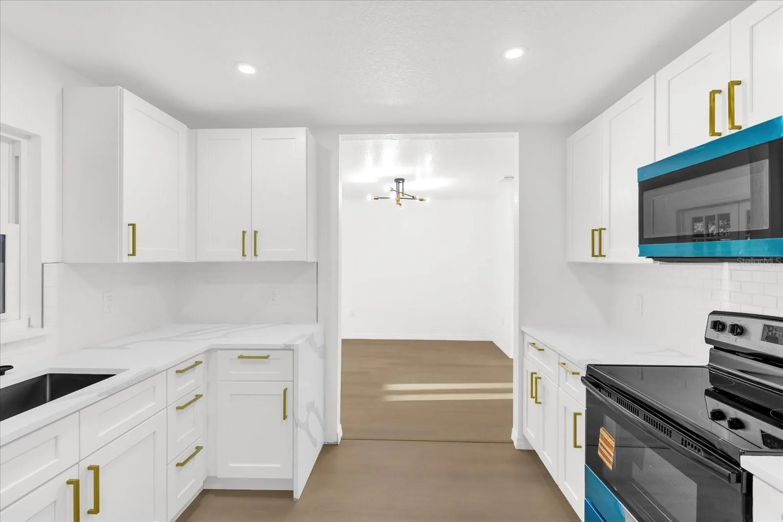 The Kitchen, approx 10x11 is centrally located for convenience. It features New Shaker Cabinets, Quartz Countertops, Brass hardware, Tiled backsplash and all new stainless steel appliances.