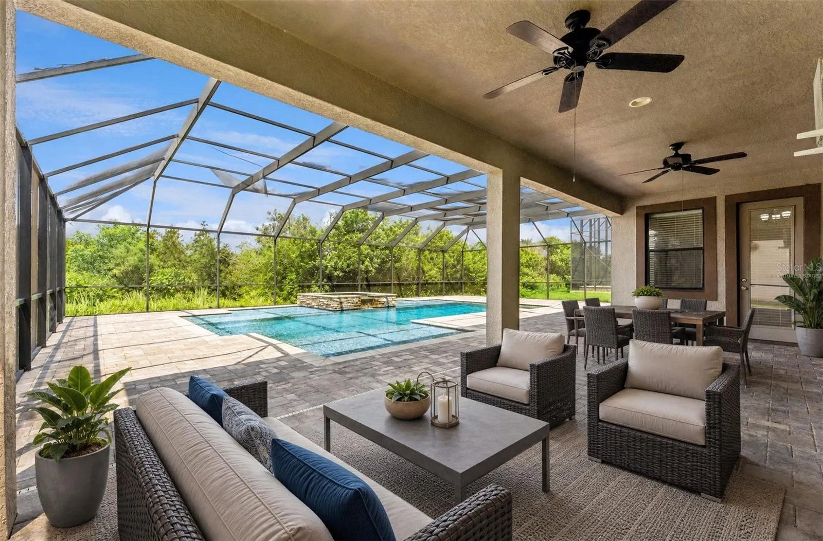 Large covered lanai overlooks your screened pool with a wooded view. Virtually Staged.