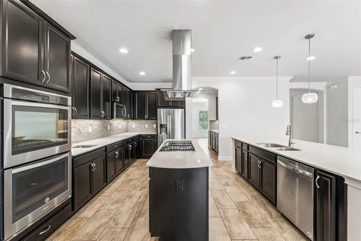Double island, natural gas cooktop, stainless steel appliances, ample cabinet and counter space, upgraded finishes and lighting.