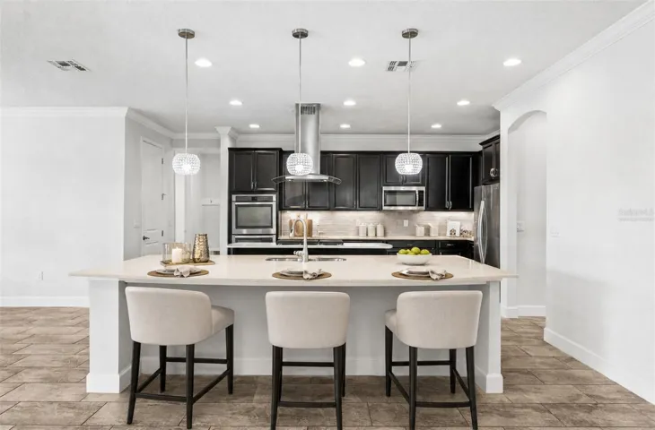 The beautifully designed kitchen serves as the heart of the home. Virtually Staged.