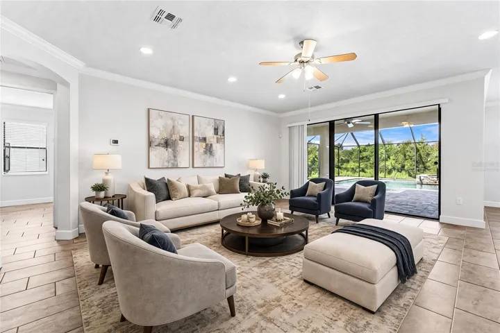 Spaicous living area has a wall of sliding glass doors that open up to the lanai and pool for the ultimate in indoor/outdoor Florida living. Virtually Staged.
