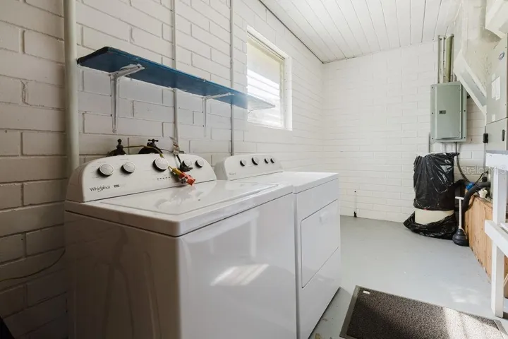 Inside laundry with electric washer and dryer. Storage and workshop space available.