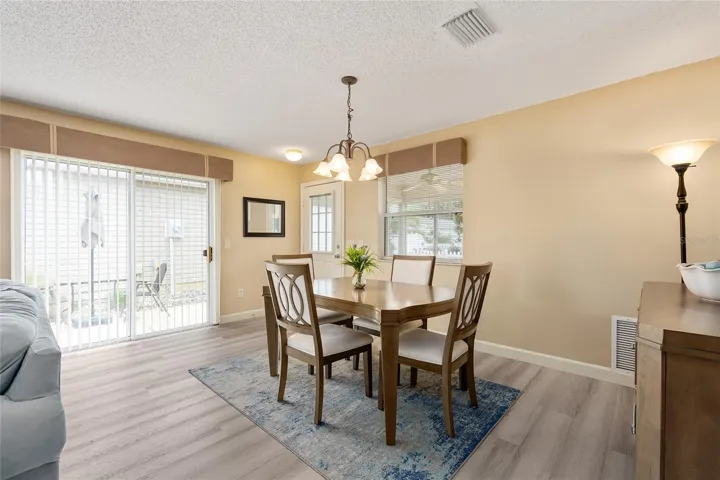 View from KITCHEN - Shows NATURAL LIGHT beaming through SLIDING GLASS DOORS which illuminates the DINING ROOM area.