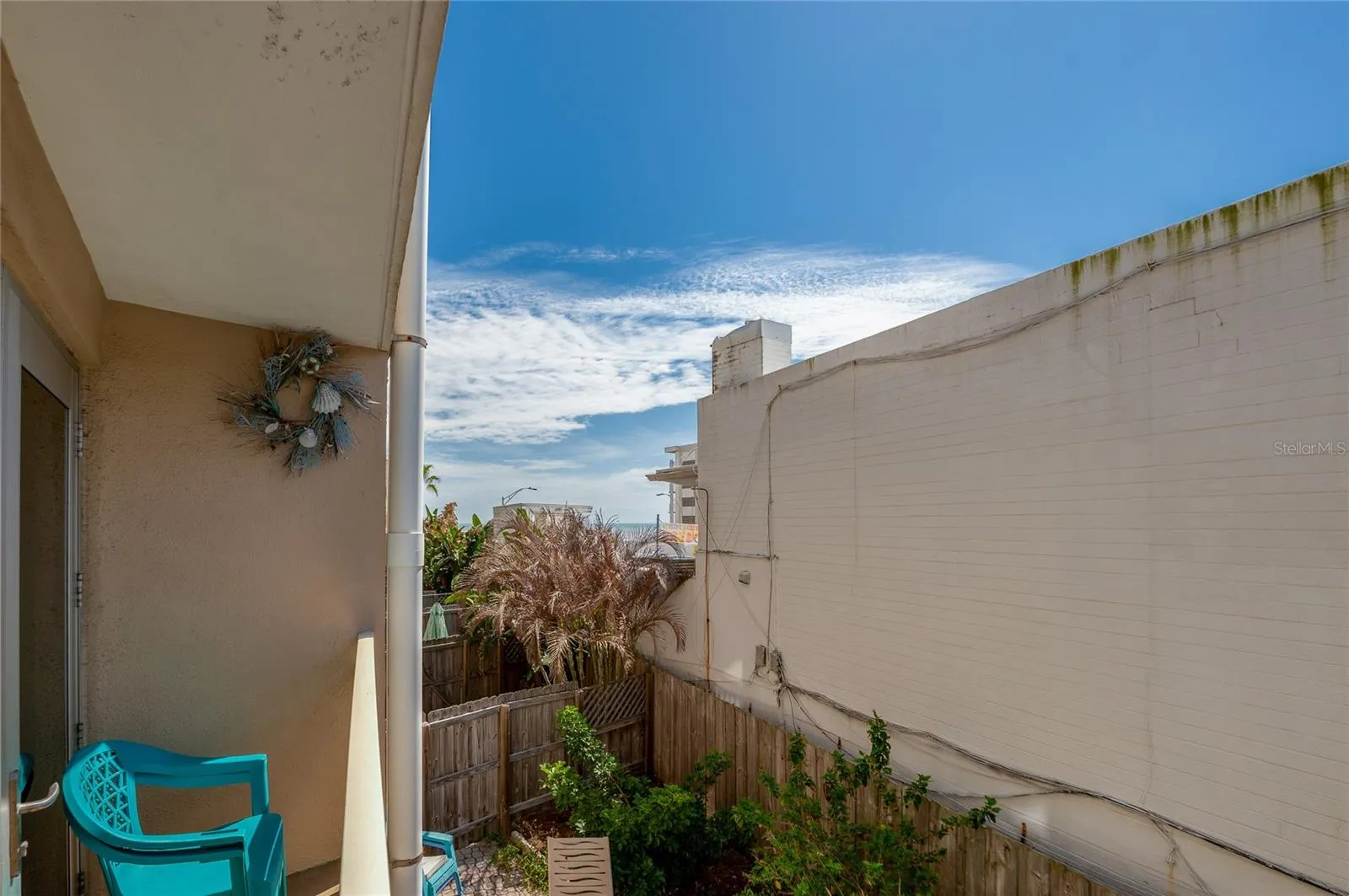 Another balcony angle highlights a comfortable space to enjoy fresh air, with a glimpse toward the shoreline at the end of the block.