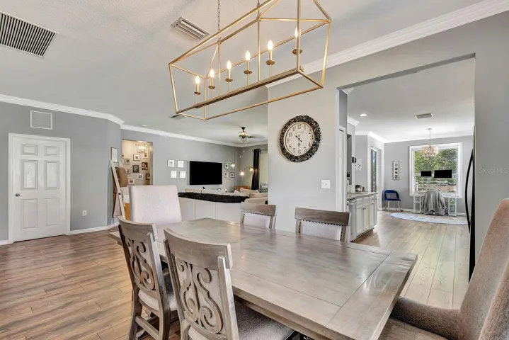 Formal dining area facing into open kitchen and living area in the background.