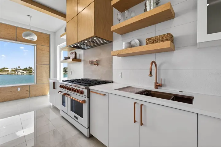 Gas range appliance with overhead vent hood.