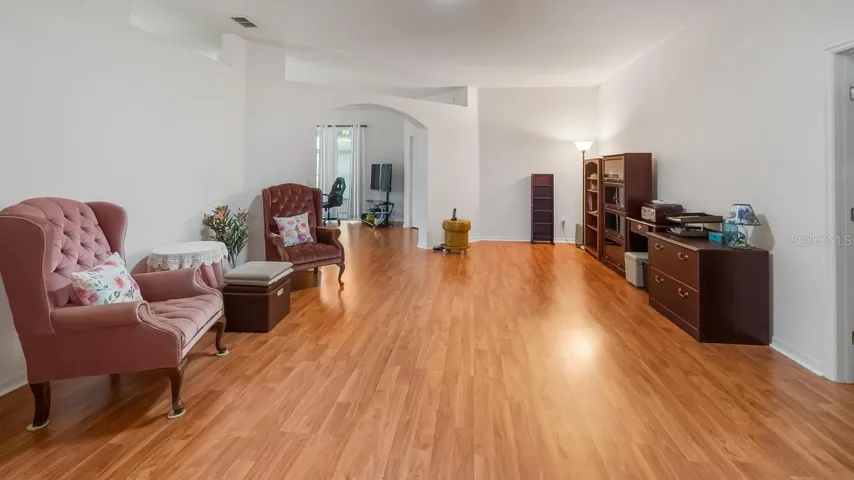 Formal Living Room With Arch Leading into Family Room