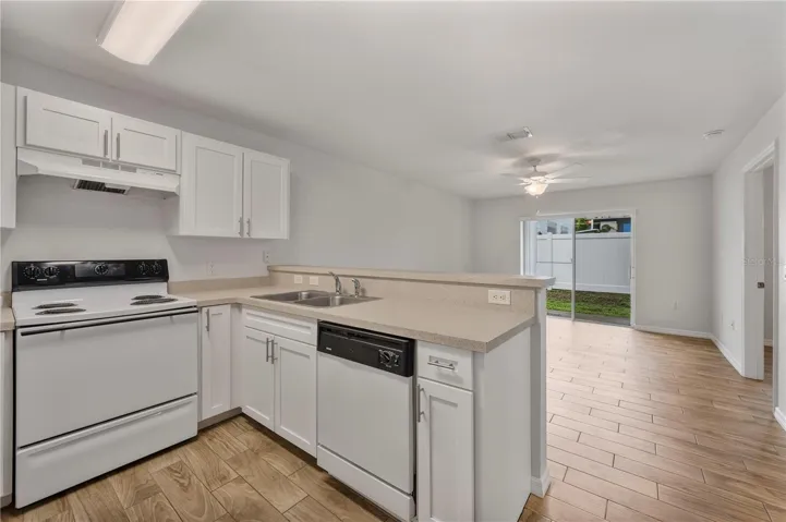 Kitchen and view into the living room and out to the rear patio, newer Wood look tile is through this unit.