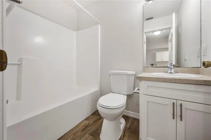Bathroom #2..features a single vanity, tub-shower combination and commode ..nicely updated.