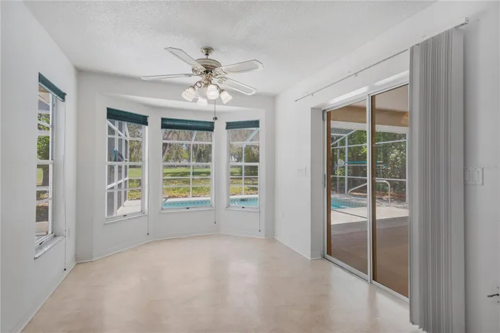 Eat-in kitchen for informal dining offers an abundance of natural light from all angles.  Set of sliders lead to covered patio.
