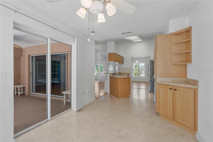 View from eat-in kitchen space to back patio and kitchen to formal dining area.