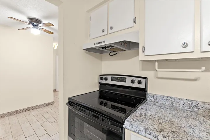 Kitchen with new electric stove looking into dining area